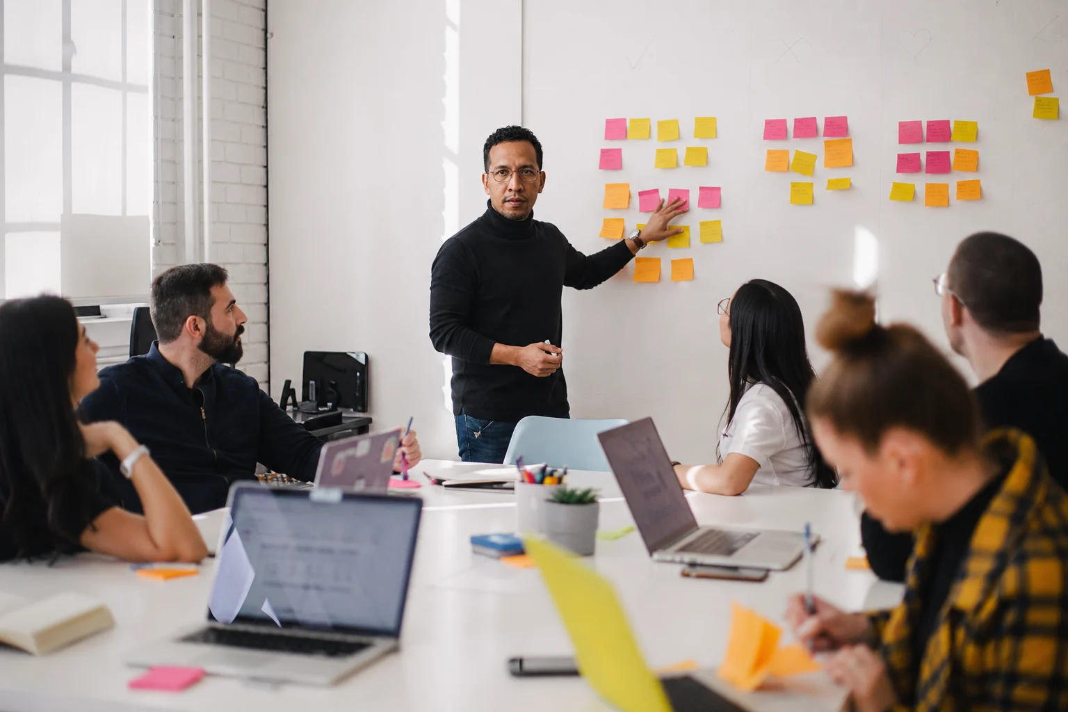 Equipo de Product Manager, Project Manager y Community Manager colaborando en una sesión de planificación estratégica con inteligencia artificial.